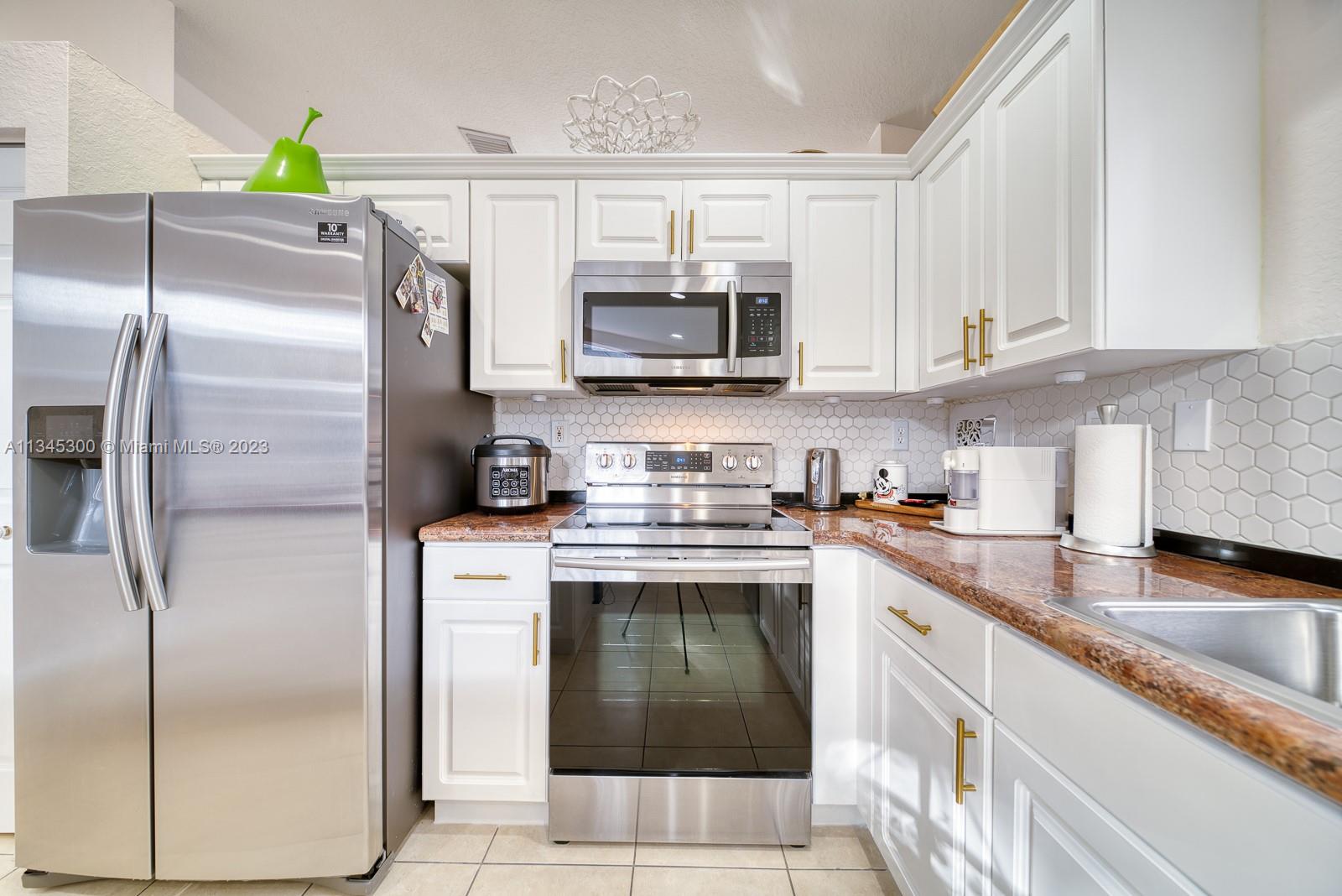 1635 Southeast 20th Place Homestead, FL 33035 - Photo 18 of 28 a kitchen with stainless steel appliances granite countertop a stove a refrigerator and a sink