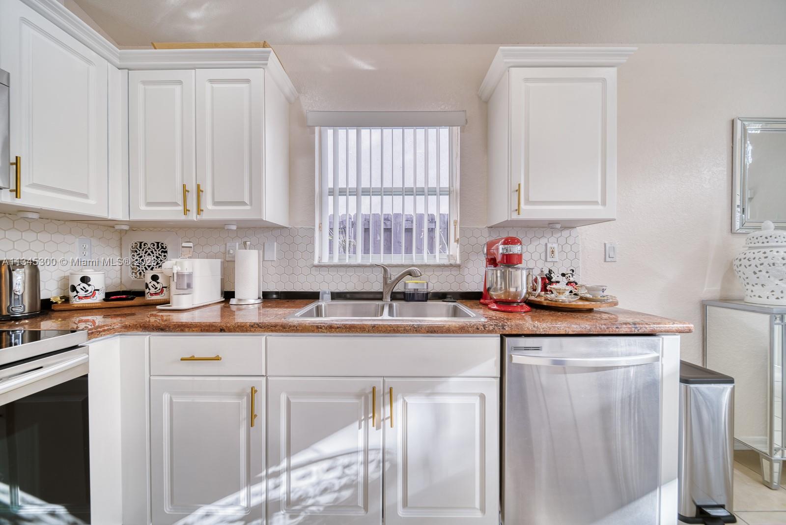 1635 Southeast 20th Place Homestead, FL 33035 - Photo 22 of 28 a kitchen with granite countertop white cabinets sink and white appliances
