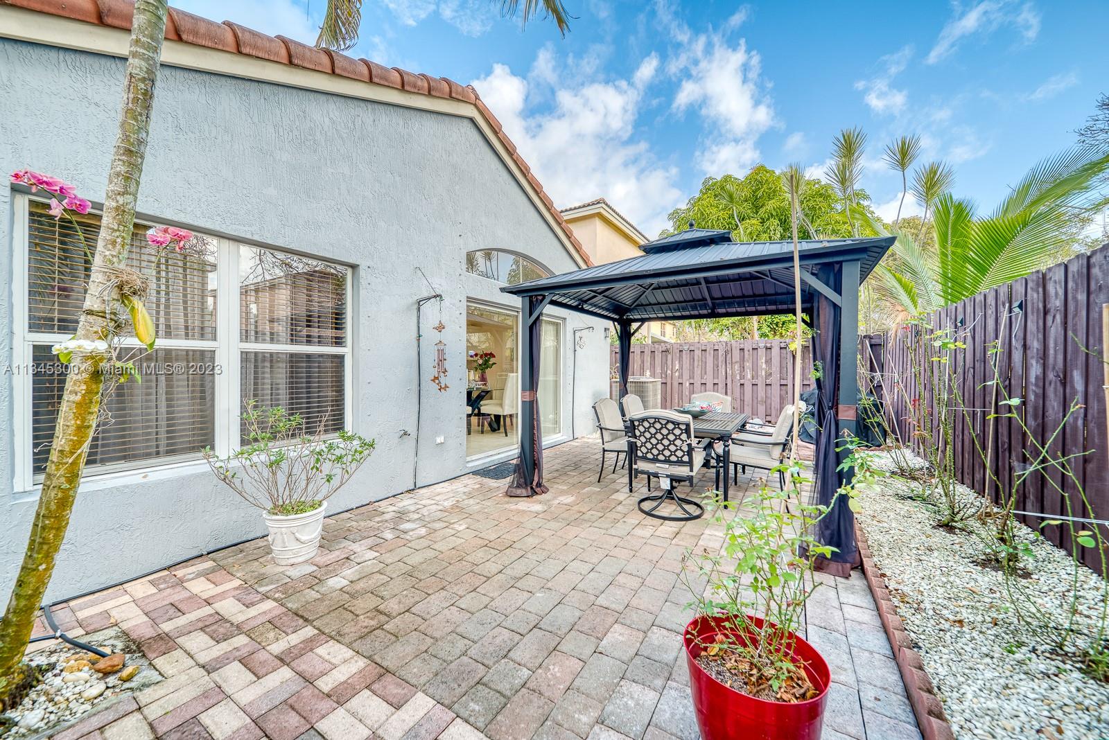 1635 Southeast 20th Place Homestead, FL 33035 - Photo 24 of 28 a view of a patio with table and chairs and potted plants