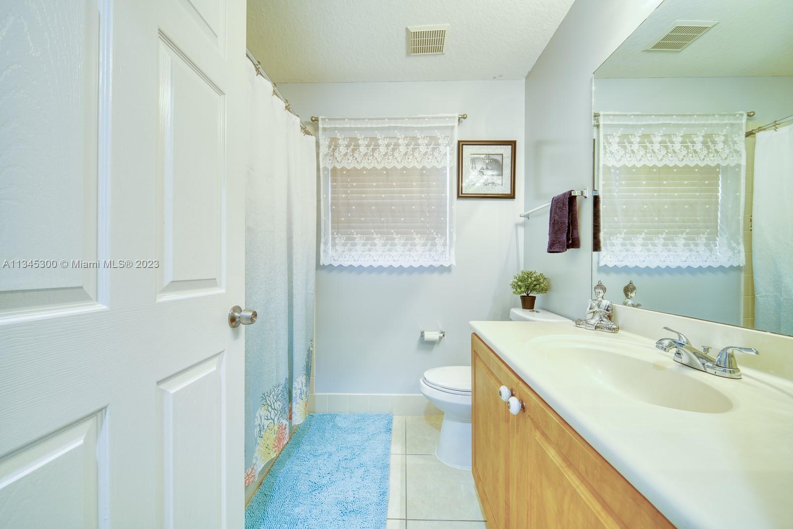 1635 Southeast 20th Place Homestead, FL 33035 - Photo 5 of 28 a bathroom with a sink a toilet and a mirror