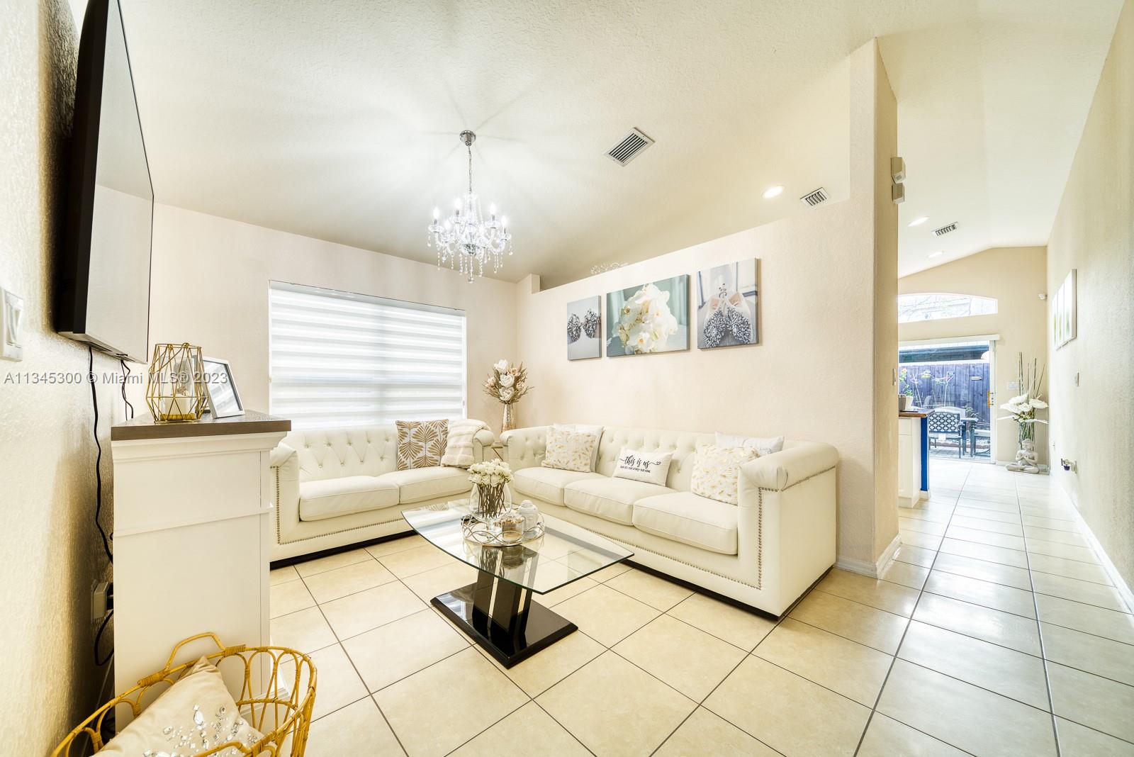 1635 Southeast 20th Place Homestead, FL 33035 - Photo 8 of 28 a living room with furniture and a chandelier