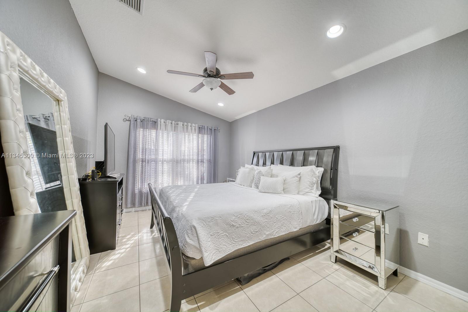 1635 Southeast 20th Place Homestead, FL 33035 - Photo 10 of 28 a bedroom with a bed a flat screen tv and a dresser