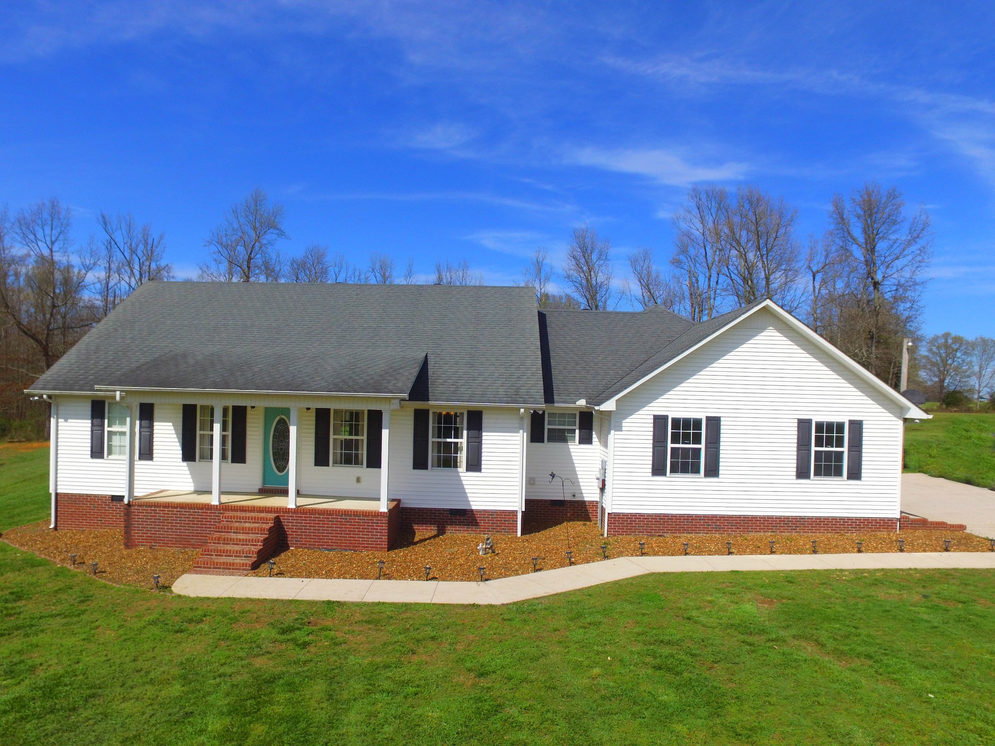 376 Spring Meadows Lane Morrison, TN 37357 - Photo 1 of 16 a view of a white house with a big yard and potted plants