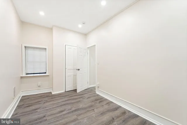 a view of an empty room with wooden floor