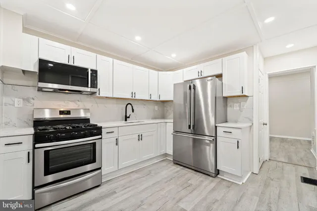 a kitchen with a stove a refrigerator and a microwave