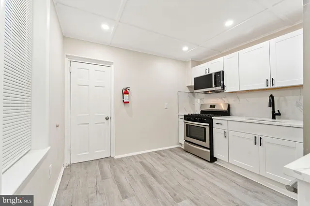 a kitchen with a sink a microwave and cabinets