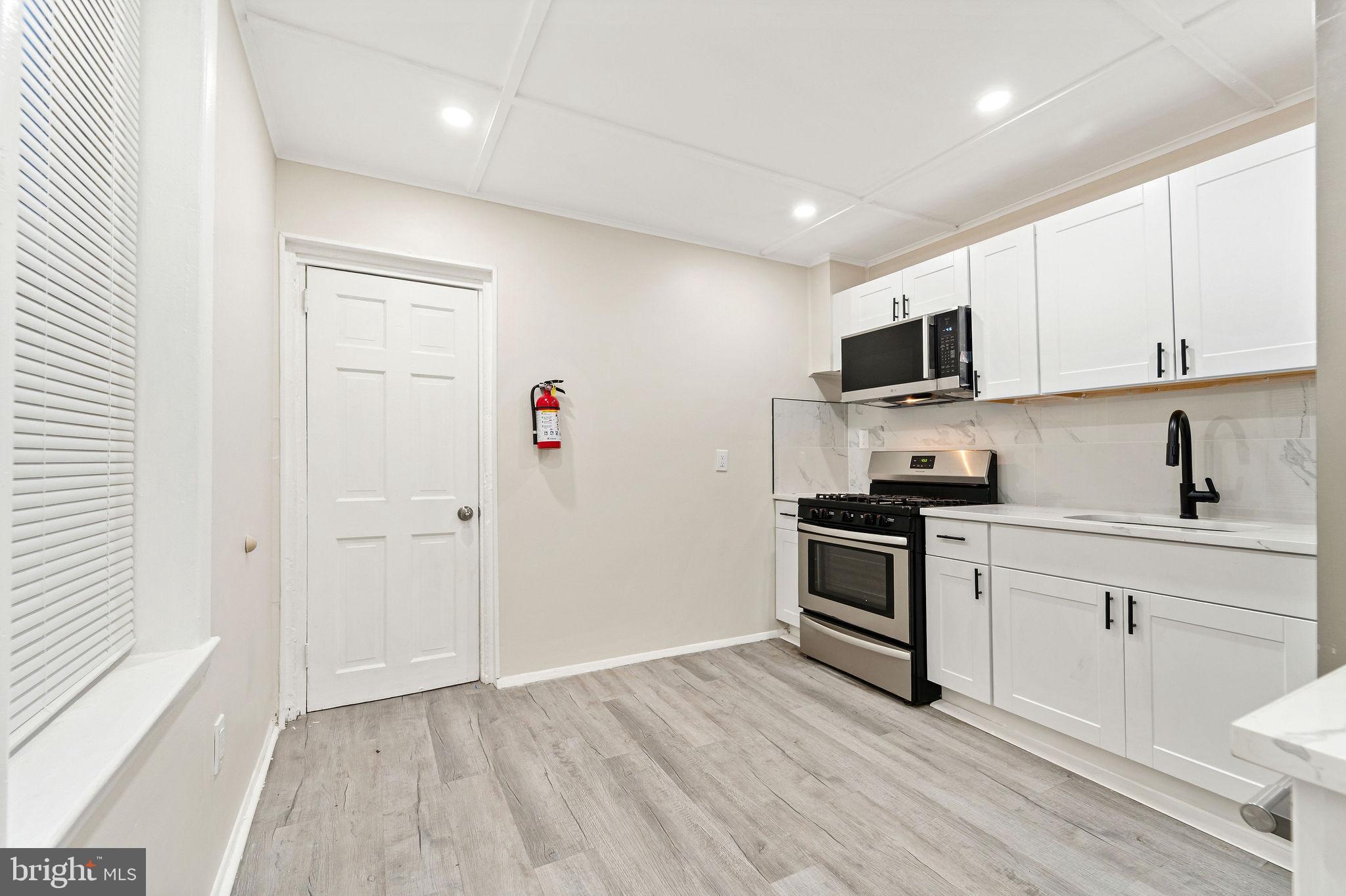 705 North 7th Street Camden, NJ 08102 - Photo 10 of 25 a kitchen with a sink a microwave and cabinets