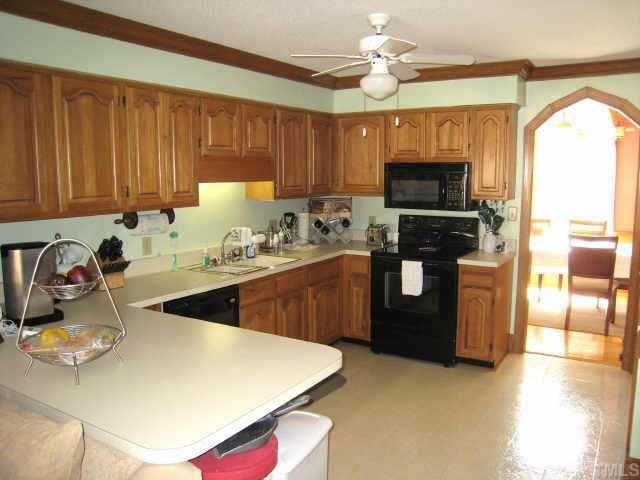 4804 Lancashire Drive Raleigh, NC 27613 - Photo 5 of 10 a kitchen with a stove a sink and a microwave