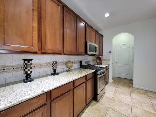 a kitchen with stainless steel appliances granite countertop a sink stove and cabinets