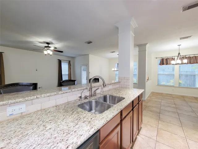 a kitchen with stainless steel appliances granite countertop a sink a stove and a refrigerator