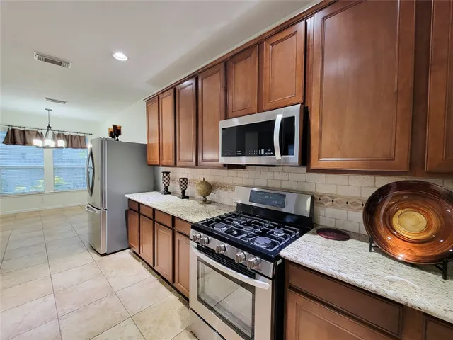a kitchen with stainless steel appliances granite countertop a stove and a microwave
