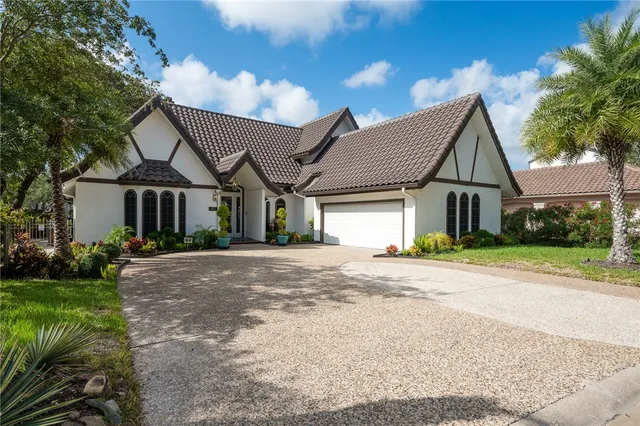 a front view of a house with a garden and plants