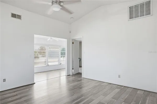 a view of a room with wooden floor and a ceiling fan
