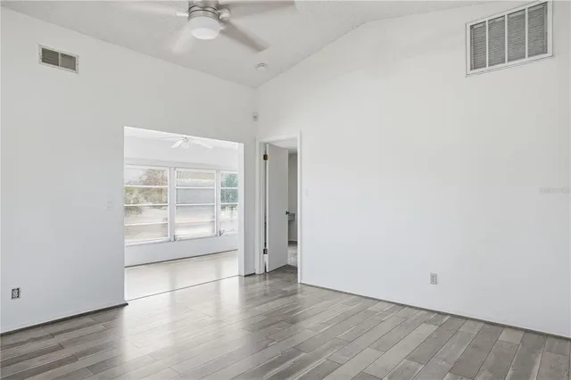 a view of a room with wooden floor and a ceiling fan
