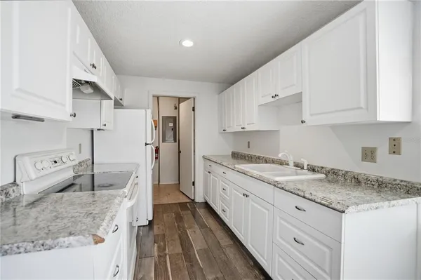 a kitchen with white cabinets and white appliances