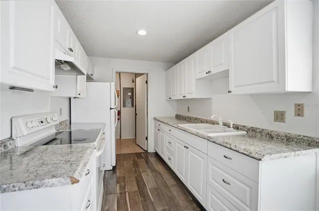 a kitchen with white cabinets and white appliances
