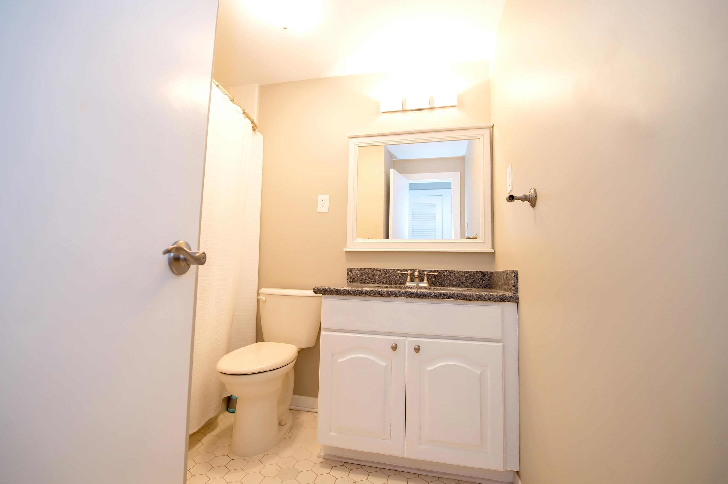 2 Allamanda Terrace Key West, FL 33040 - Photo 18 of 29 a bathroom with a granite countertop toilet a sink and a mirror