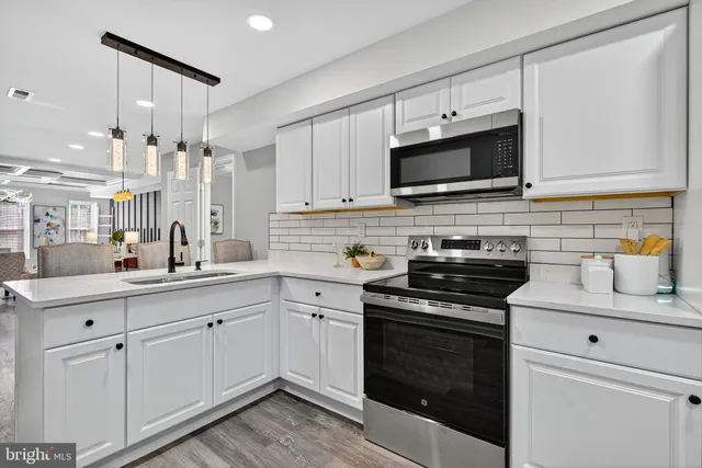 a kitchen with stainless steel appliances granite countertop a stove a sink and a microwave