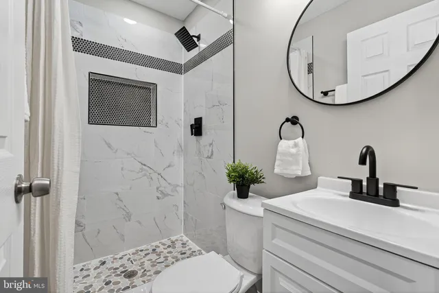 a bathroom with a sink a toilet and shower