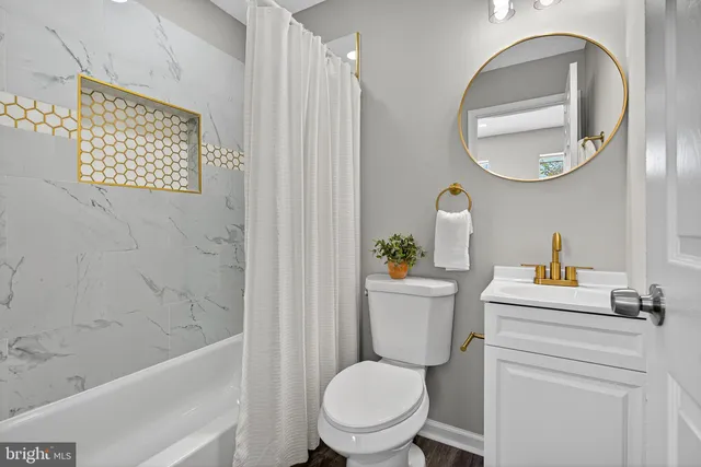 a white toilet sitting next to a bathroom sink and tub