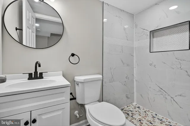 a bathroom with a sink a toilet and a mirror