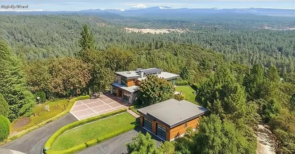 an aerial view of a house with a yard and lake view