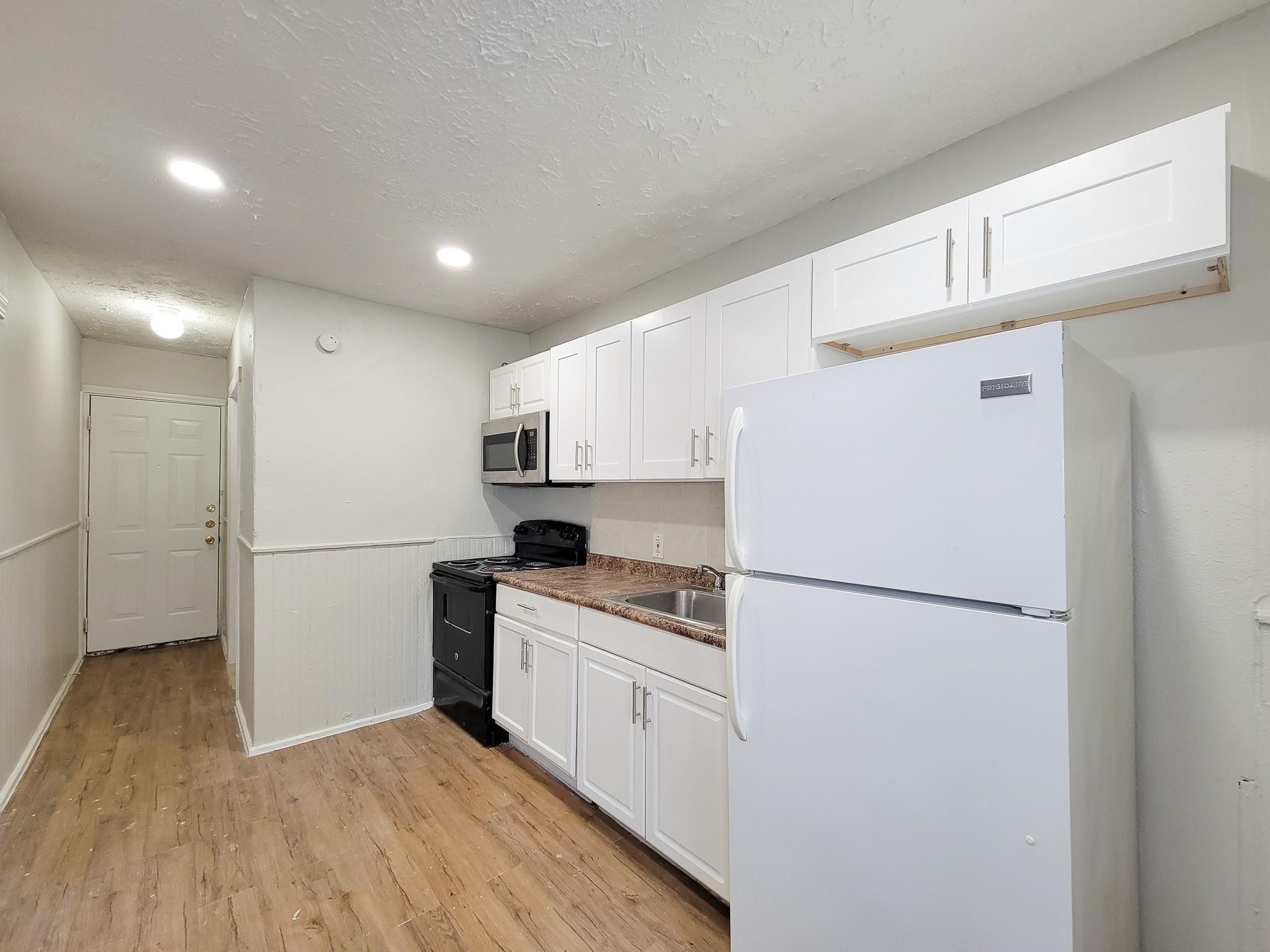 711 Ave A, Unit 4 La Marque, TX 77568 - Photo 13 of 21 a kitchen with a refrigerator a sink and dishwasher