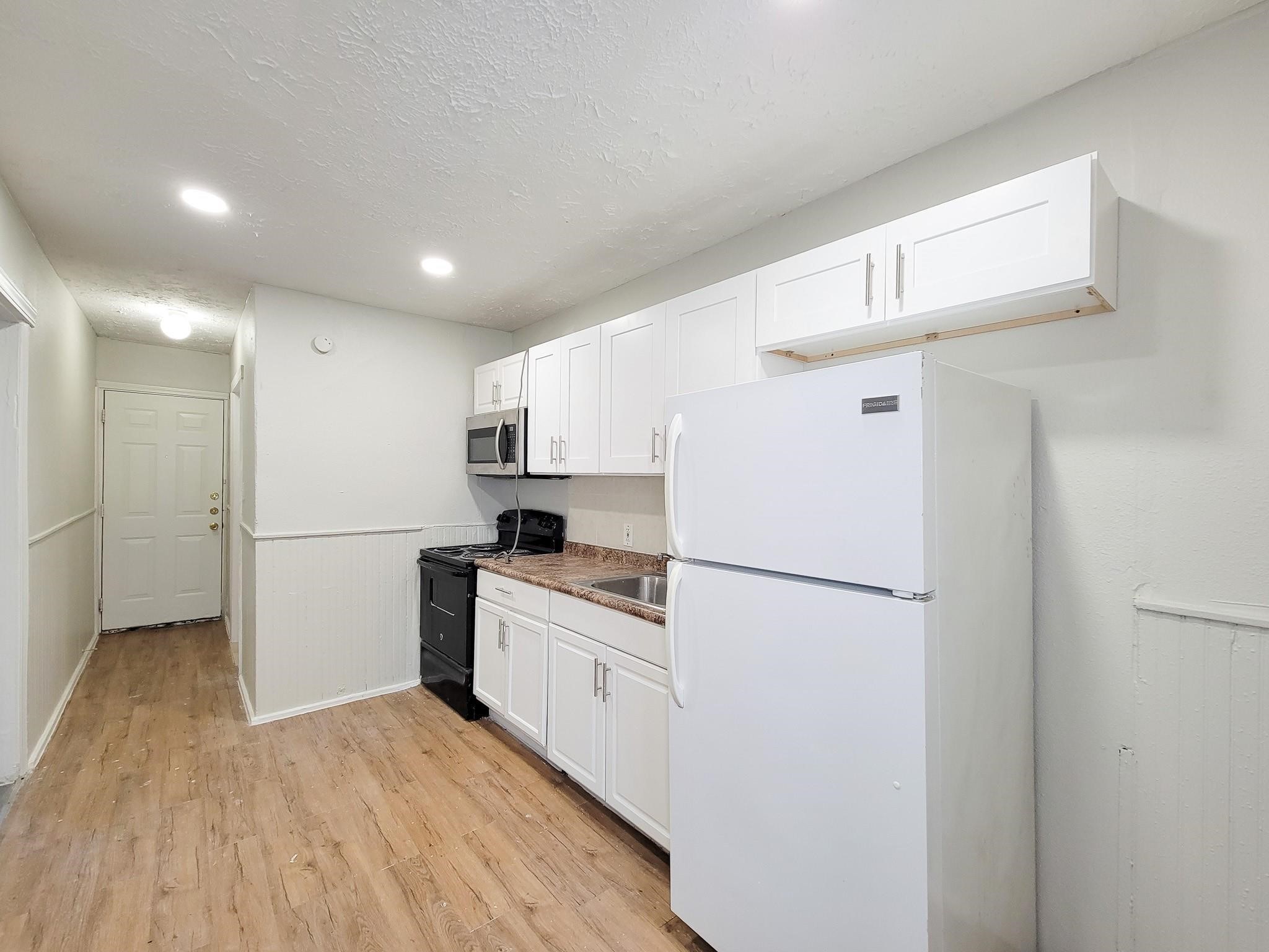711 Ave A, Unit 4 La Marque, TX 77568 - Photo 14 of 21 a kitchen with stainless steel appliances a refrigerator sink and cabinets