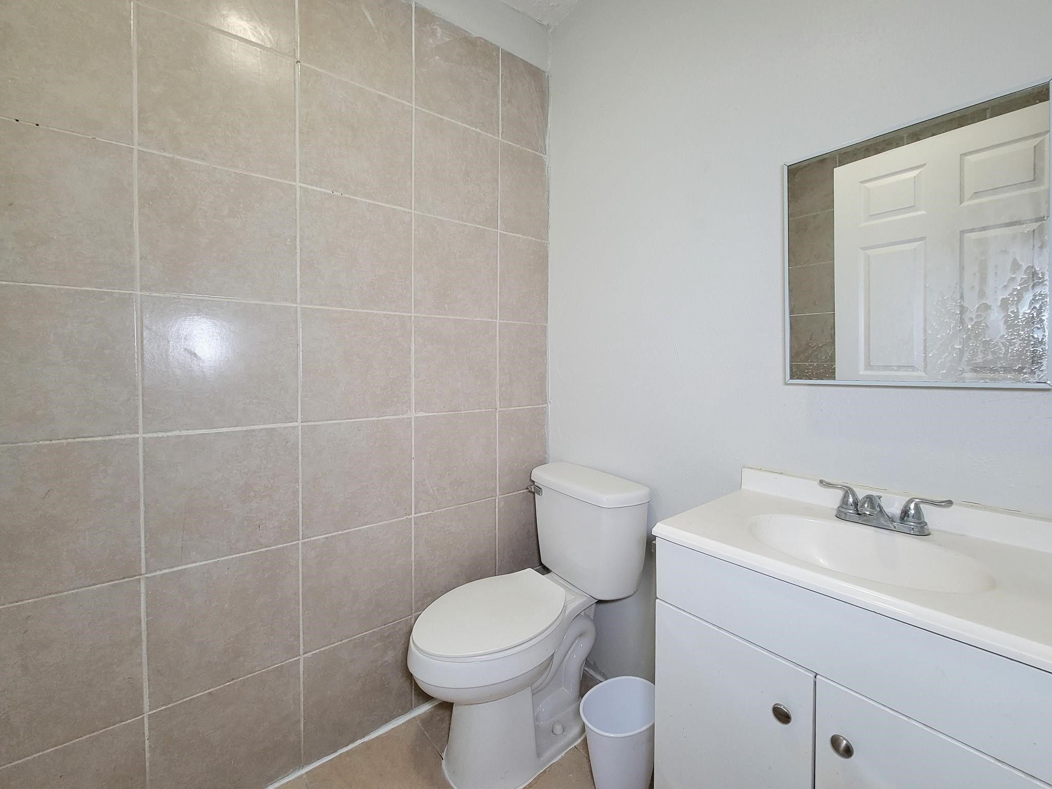 711 Ave A, Unit 4 La Marque, TX 77568 - Photo 18 of 21 a bathroom with a toilet sink and mirror