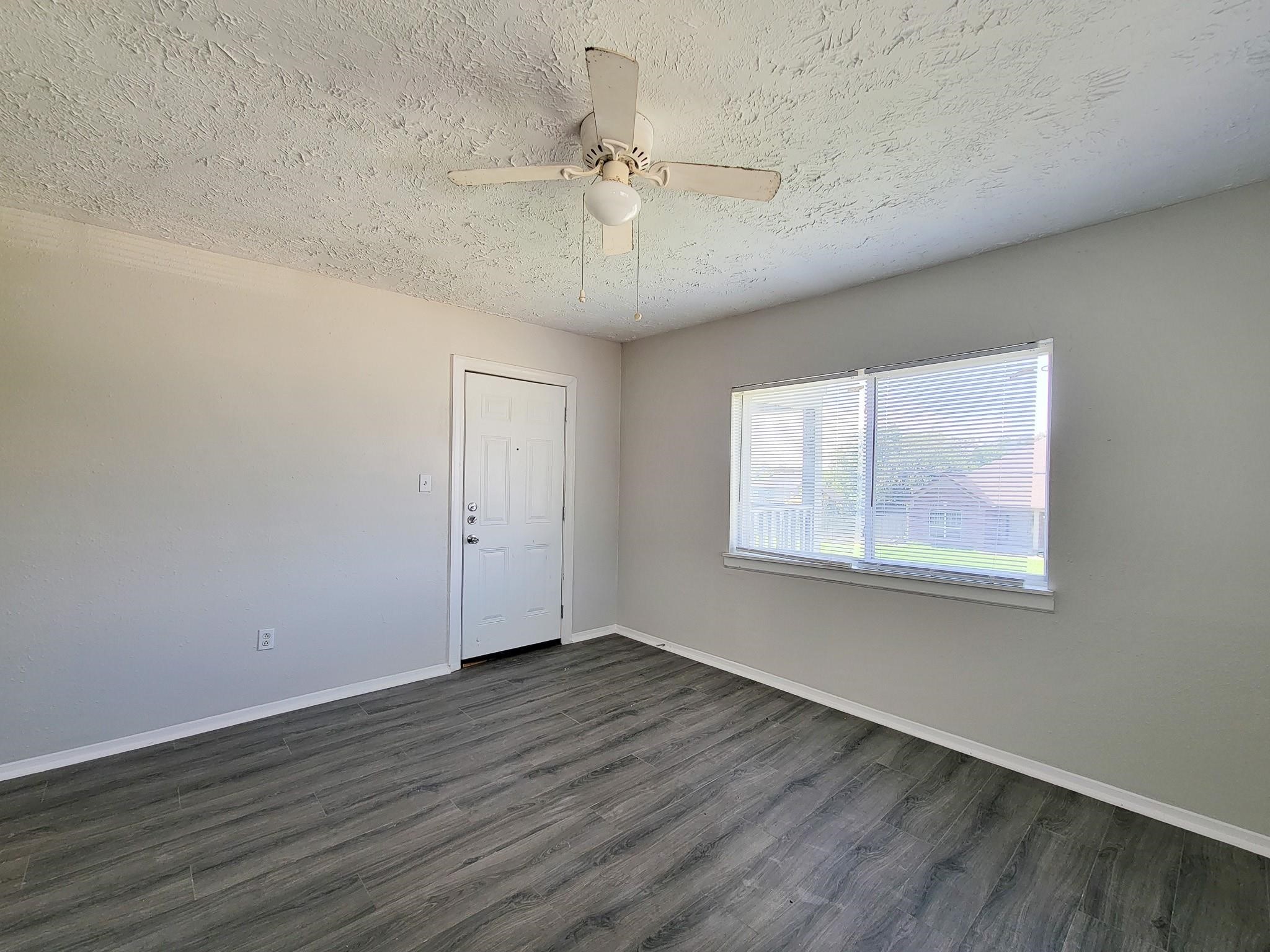 711 Ave A, Unit 4 La Marque, TX 77568 - Photo 5 of 21 a view of an empty room with wooden floor and a window
