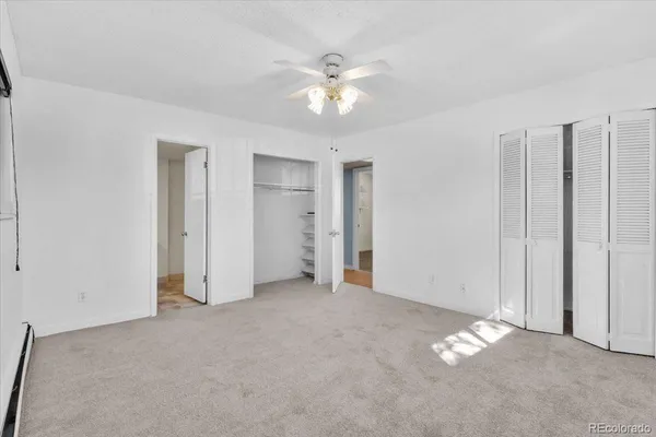 a view of an empty room with a ceiling fan