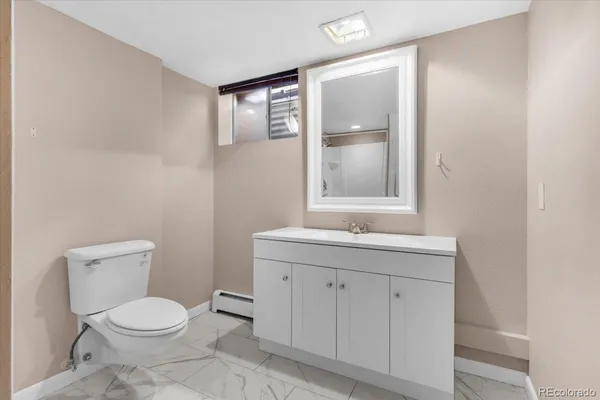 a bathroom with a granite countertop toilet a sink and mirror