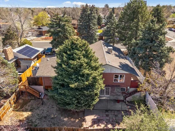 an aerial view of a house with a yard and large trees