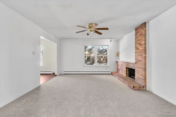 an empty room with windows and fireplace