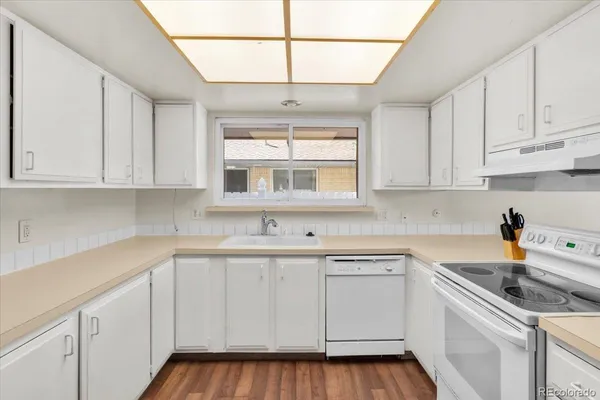 a kitchen with white cabinets and white appliances