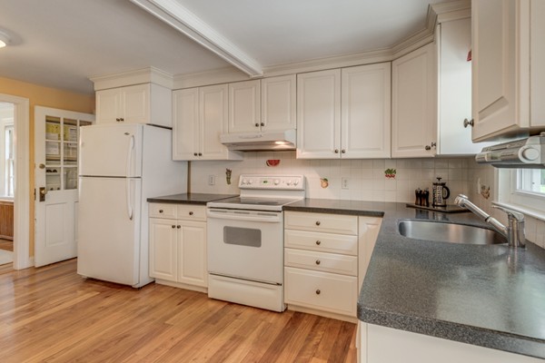 100 Mayflower Road Needham, MA 02492 - Photo 16 of 28 a kitchen with granite countertop white cabinets and refrigerator