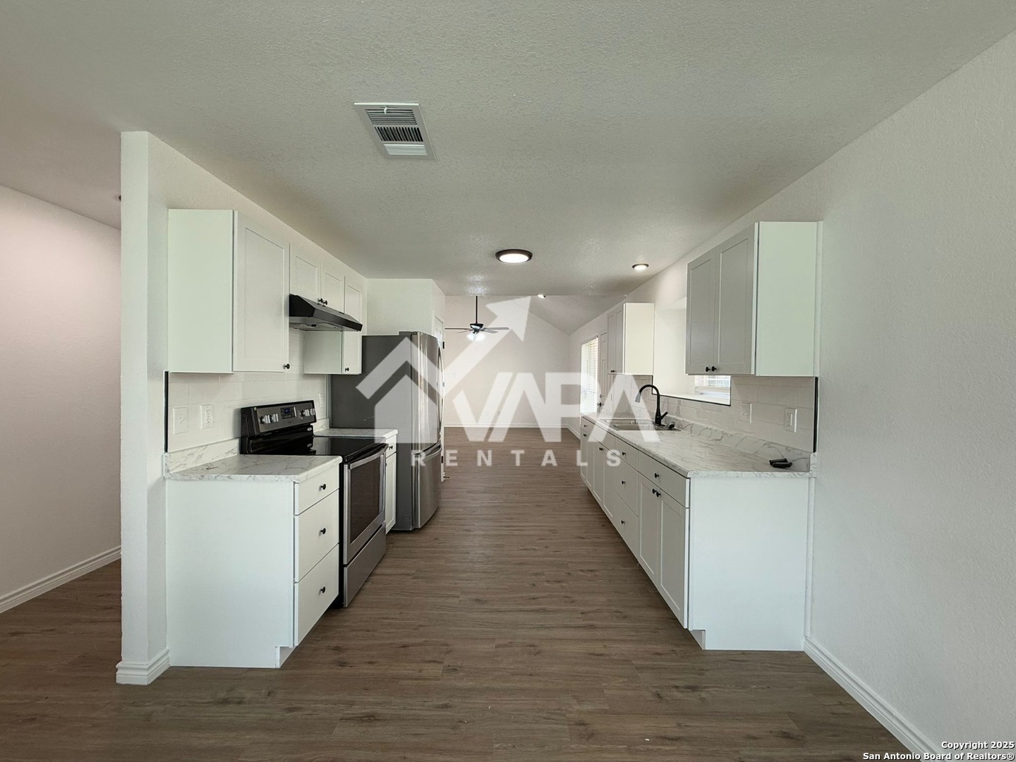 6406 Gray Ridge San Antonio, TX 78233 - Photo 6 of 15 a large kitchen with stainless steel appliances a large counter top a stove a chimney a sink and dishwasher