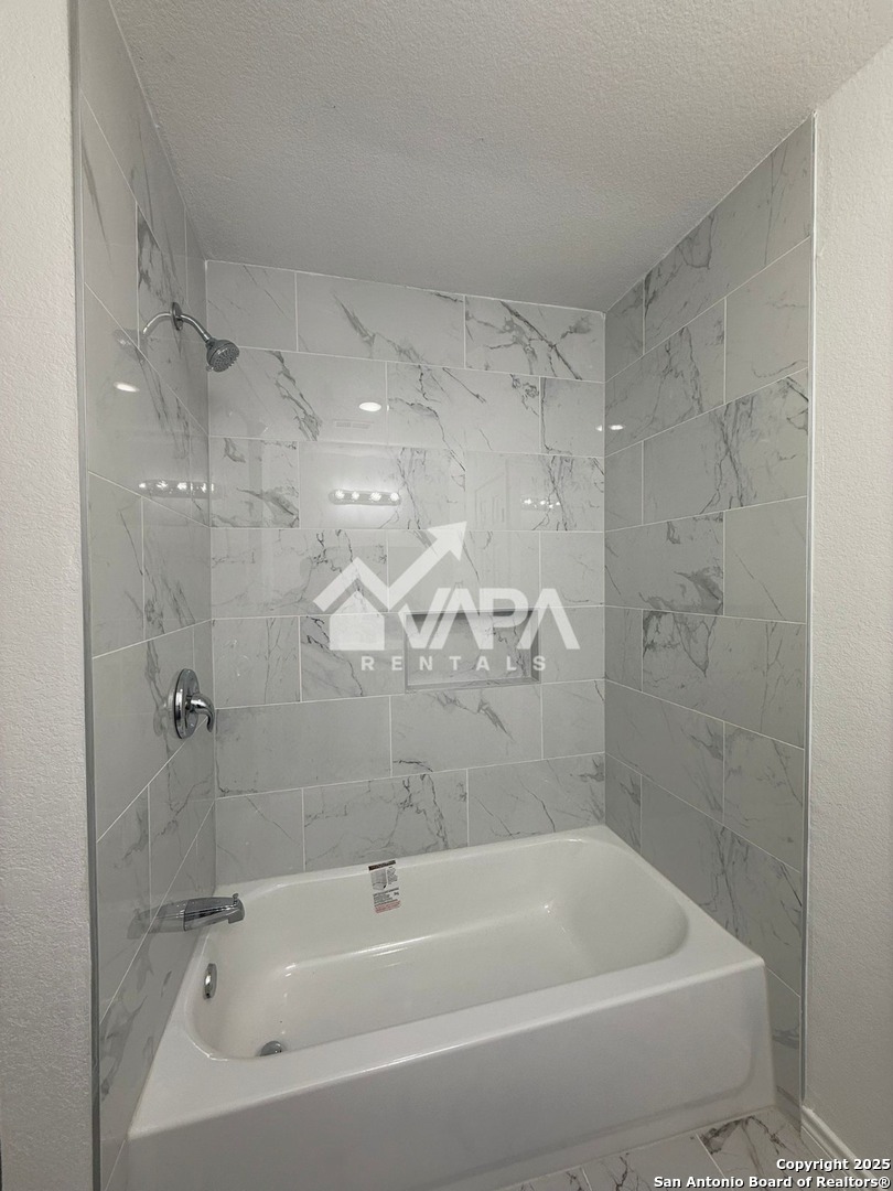 6406 Gray Ridge San Antonio, TX 78233 - Photo 8 of 15 a bathroom with a bathtub and a shower