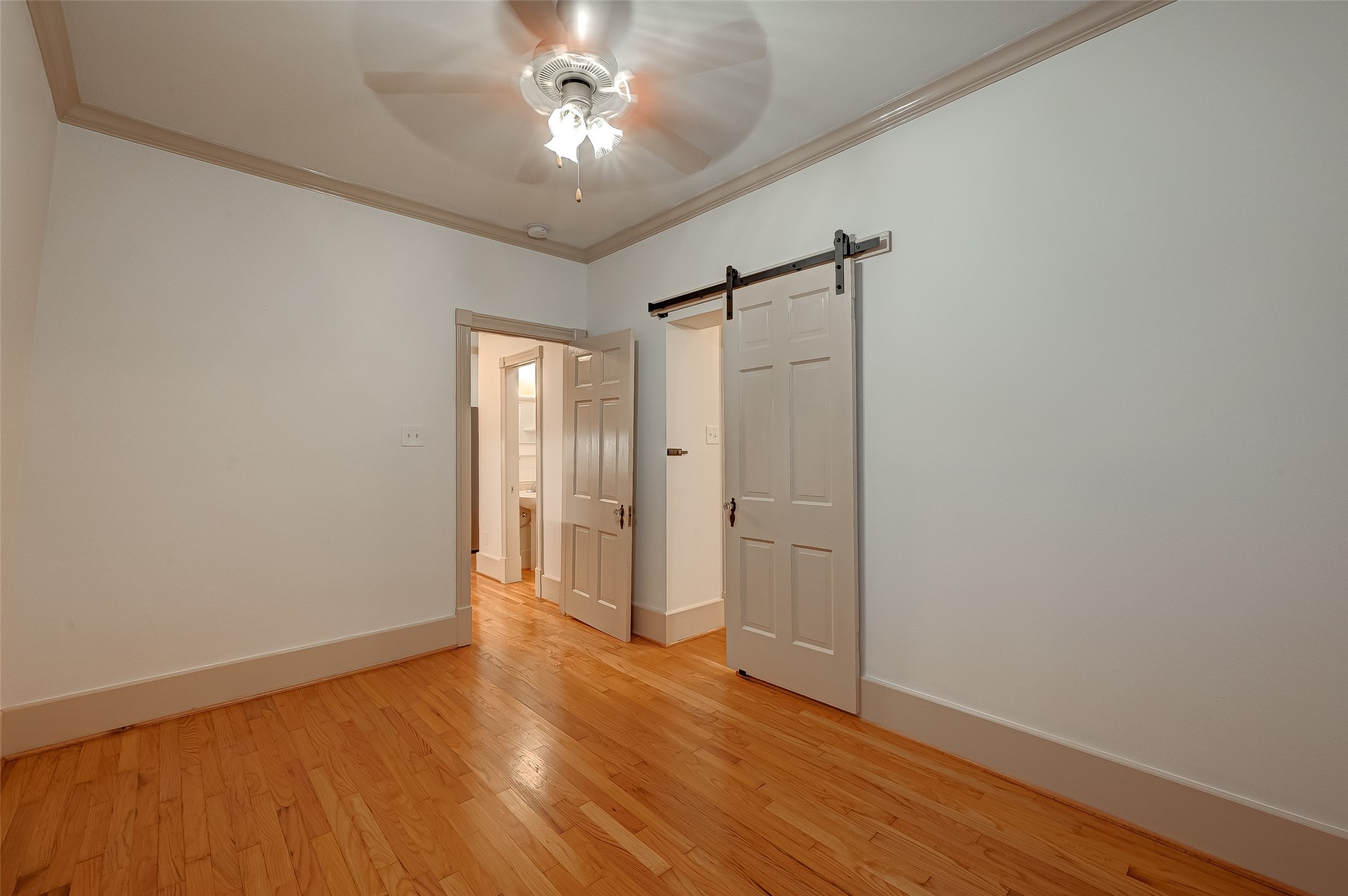 2009 State Street Houston, TX 77007 - Photo 14 of 42 Primary bedroom with hanging hinged door that opens on to the primary bath