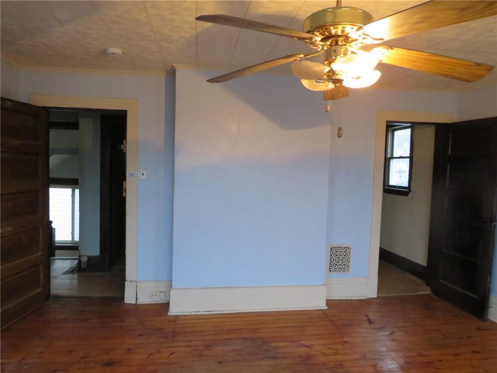 1203 2nd Avenue Conway, PA 15027 - Photo 18 of 43 an empty room with wooden floor and chandelier fan
