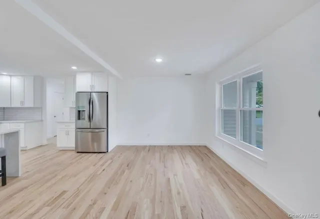 a view of a kitchen with a fridge and wooden floor