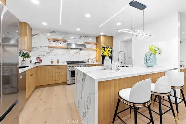 a kitchen with kitchen island granite countertop a sink a center island and stainless steel appliances