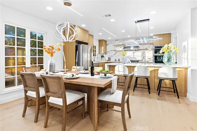 a dining area with a table chairs and a kitchen view