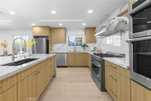 a kitchen with kitchen island granite countertop a sink stainless steel appliances and cabinets