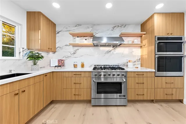 a kitchen with stainless steel appliances a stove a sink and a microwave
