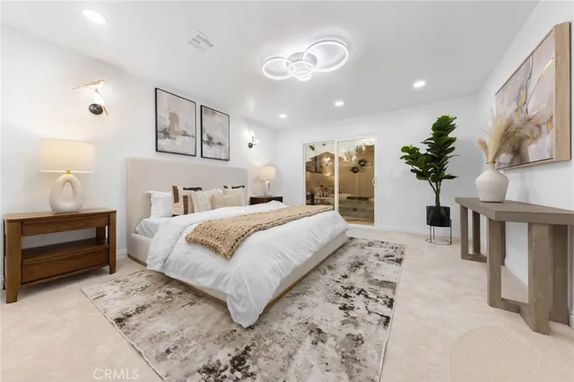 a bedroom with a large bed and a chandelier