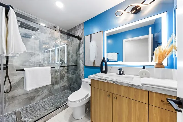 a bathroom with a granite countertop sink a mirror and shower