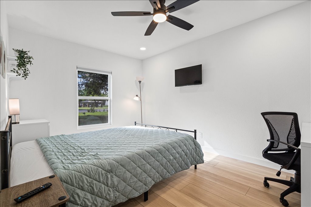 1406 North Georgetown Street Round Rock, TX 78664 - Photo 8 of 34 A well-lit bedroom features hardwood flooring and a functional ceiling fan for optimal comfort.