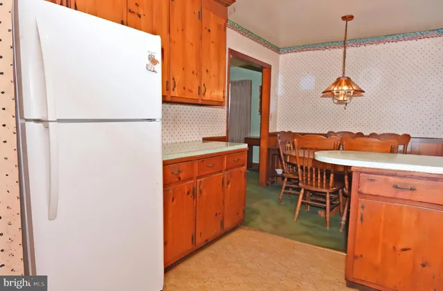 a dining table chairs and a refrigerator in a kitchen