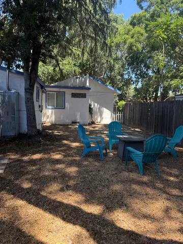a white house that has a tree in front of it